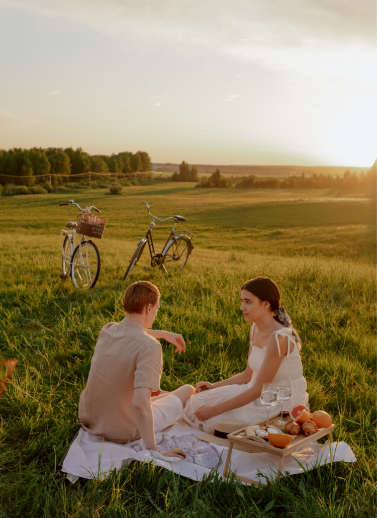 couple having a midday picnic in a field
