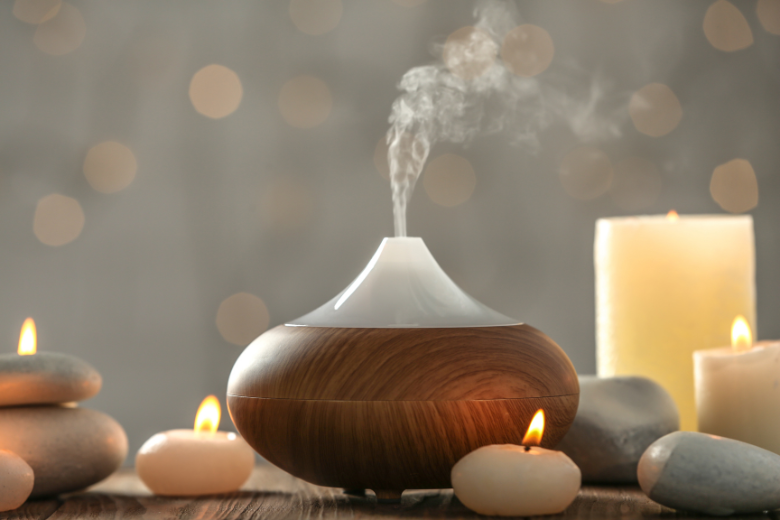 wooden diffuser surrounded by candles and rocks