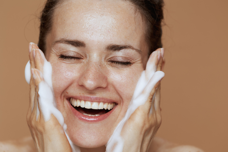 woman happily cleansing her face
