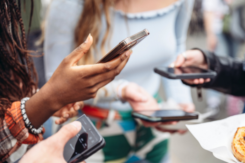 black-woman-standing-with-friends-using-phones